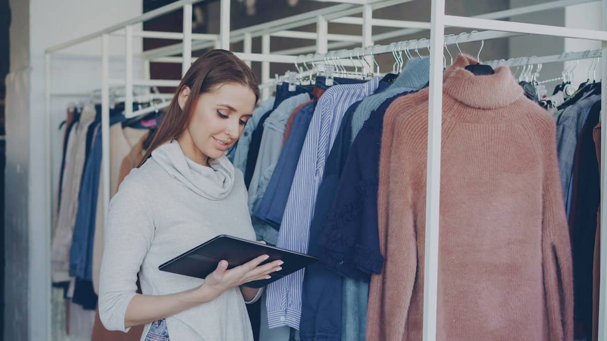 Une commerçante fait l'inventaire de son rayon sur une tablette.